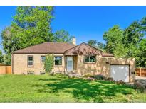 Charming brick ranch home featuring mature trees, green lawn, and attached single car garage at 4685 Wadsworth Blvd, Wheat Ridge, CO 80033