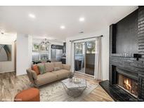 Inviting living room with a cozy fireplace and sliding glass doors to the outdoor patio at 8035 W Eastman Pl # 106, Lakewood, CO 80227