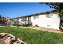 Charming single story home featuring a well-kept front yard, flowers, and a cozy front porch at 7100 Saulsbury St, Arvada, CO 80003