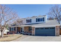 Charming two-story home with brick facade, blue shutters, well-kept lawn, and a two-car garage at 8070 Johnson Ct, Arvada, CO 80005