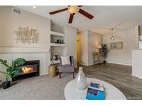 Cozy living room featuring a fireplace, ceiling fan, and neutral color palette at 10784 W 63Rd Pl # 204, Arvada, CO 80004