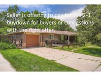 Charming brick home with a front yard and a driveway leading to an attached garage at 4365 Kendall St, Wheat Ridge, CO 80033