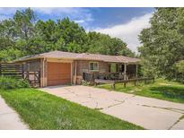 Charming brick home with a well-maintained yard, featuring a single-car garage and mature trees at 4365 Kendall St, Wheat Ridge, CO 80033