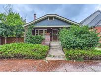 Charming home featuring lush landscaping, brick accents, and a cozy front porch at 579 S Sherman St, Denver, CO 80209