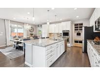Bright kitchen boasts a spacious island, stainless appliances, and opens to the dining area at 10397 Helsinki St, Parker, CO 80134