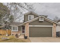 Two-story house with a brick and siding exterior, attached garage, and landscaped yard at 10491 Tiger Run, Lone Tree, CO 80124