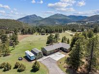 Aerial view of a home, garage, camper, and mountains in the background at 30651 Hollings Way, Golden, CO 80403