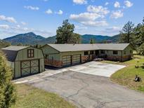 Ranch-style home with a detached garage and mountain views at 30651 Hollings Way, Golden, CO 80403