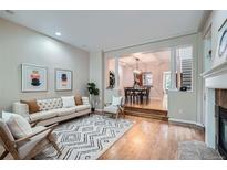 Bright living room with hardwood floors, fireplace, and an open floor plan to the dining area at 222 S Monroe St, Denver, CO 80209