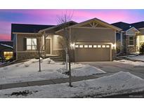 Attractive ranch home with a two-car garage and snow-covered landscaping at 22046 E Allenspark Pl, Aurora, CO 80016
