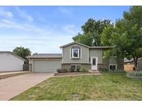 Charming two-story home with landscaped front yard, lush green grass, and attached two-car garage at 11823 Steele St, Thornton, CO 80233