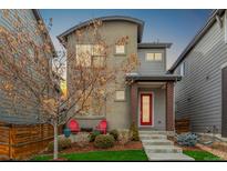 Two-story modern home with red door and landscaped front yard at 6777 Larsh Dr, Denver, CO 80221