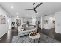 Open-concept living room featuring a ceiling fan, modern gray decor and dark hardwood floors at 452 S Norfolk Ct, Aurora, CO 80017