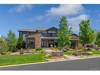Stunning home featuring a stone and siding exterior, beautifully landscaped yard, and well-maintained lawn at 10826 Evergold Way, Highlands Ranch, CO 80126