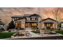Stunning stone-clad home featuring a professionally landscaped front yard and charming walkway at 10826 Evergold Way, Highlands Ranch, CO 80126