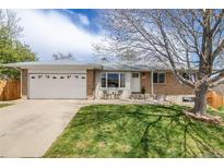 Charming ranch-style home featuring a well-manicured lawn, brick accents, and an attached two-car garage at 13367 W Montana Pl, Lakewood, CO 80228