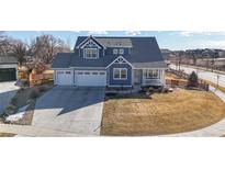 Charming two-story home with three-car garage, covered porch, and well-maintained lawn at 885 Delechant Dr, Erie, CO 80516
