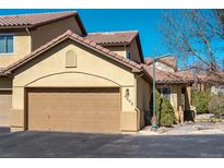 Attached two-car garage with a beige door and a tan stucco exterior, part of a well-maintained home at 4648 S Abilene Cir, Aurora, CO 80015