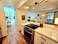 Modern kitchen featuring stainless steel appliances and open access to an adjoining living space at 1073 W Powers Ave, Littleton, CO 80120