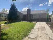 Ranch home with brick facade, driveway, and grassy yard at 1645 Iola St, Aurora, CO 80010