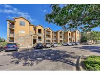 Inviting condo complex featuring stone accents, balconies, and ample parking in a well-maintained community at 17497 Nature Walk Trl # 302, Parker, CO 80134