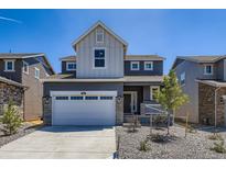 Charming two-story home featuring a stone-accented garage and a welcoming front porch in a modern neighborhood at 662 N Clubview St, Watkins, CO 80137