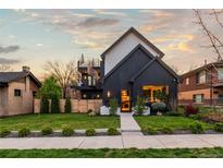 Striking two-story modern home featuring dark siding, manicured lawn, and sidewalk leading to the entrance at 2921 Newton St, Denver, CO 80211