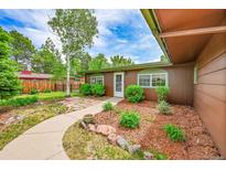 Charming single-story home boasts a welcoming front yard with mature trees and a stone walkway to the front door at 5722 W Chestnut Ave, Littleton, CO 80128