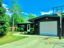 Charming home featuring an attached garage, lush lawn, mature trees and driveway basketball hoop at 5722 W Chestnut Ave, Littleton, CO 80128