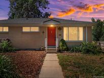 Charming brick home with a well-maintained front yard and a bright red front door, perfect for a welcoming entrance at 14050 E 25Th Pl, Aurora, CO 80011
