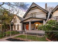 Charming grey two-story home with a cozy front porch and vibrant orange front door at 2244 N Washington St, Denver, CO 80205