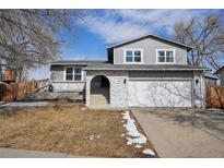 Charming two-story home featuring an attached two-car garage and an inviting arched entryway with brick accents at 9587 W 89Th Pl, Broomfield, CO 80021