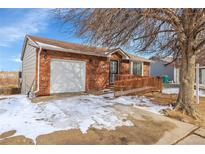 Charming red brick home featuring a convenient wheelchair ramp and an attached garage at 4678 S Salida St, Aurora, CO 80015