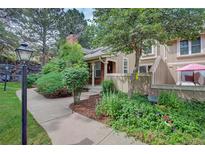 Charming townhome with brick accents, lush landscaping, and a cozy patio area for outdoor enjoyment at 2713 W Long Dr # C, Littleton, CO 80120