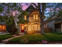 Charming two-story home with a red door, lush lawn, and mature trees at 848 S Emerson St, Denver, CO 80209