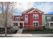 Charming red two-story home with a welcoming front porch and well-maintained landscaping at 8460 E 54Th Dr, Denver, CO 80238