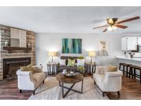 Inviting living room with stone fireplace, ceiling fan, and neutral decor at 1239 S Flower Cir # C, Lakewood, CO 80232