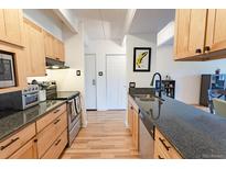 Bright kitchen featuring granite counters, stainless appliances, and wood cabinets at 777 N Washington St # 508, Denver, CO 80203
