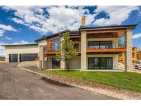 Beautiful exterior of home with stone accents, wood beams, and a two-car garage at 5820 Powell Rd, Parker, CO 80134