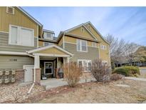 Two-story townhome with front porch and landscaping at 11899 Oak Hill Way # E, Commerce City, CO 80640