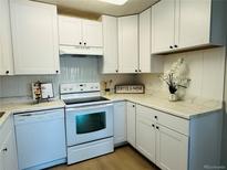Bright kitchen featuring white cabinetry, sleek appliances, and light countertops at 755 S Alton Way # 12C, Denver, CO 80247