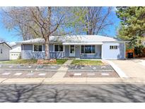 Charming light blue single story home with mature trees, tidy landscaping, and a welcoming walkway at 2561 S Carey Way, Denver, CO 80222