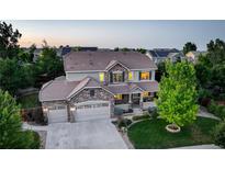Stunning two-story home featuring a three-car garage, well-manicured lawn, and inviting front porch at 4649 Spinning Wheel Dr, Brighton, CO 80601