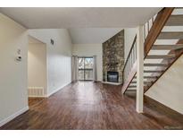 Spacious living room featuring hardwood floors, a stone fireplace, and access to a balcony at 218 Wright St # 303, Lakewood, CO 80228