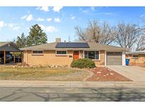 Charming single-story brick home featuring a well-manicured front yard and solar panels at 8235 Auburn Ln, Westminster, CO 80031
