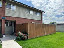 Charming townhouse with brick accents, a well-kept lawn, and a privacy fence, perfect for outdoor enjoyment at 8047 Wolff St # H, Westminster, CO 80031