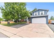 Charming two-story home with a well-manicured lawn, mature trees, and an attached two-car garage at 8977 W Toller Ave, Littleton, CO 80128
