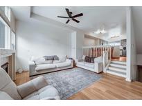 Bright living room featuring white sofas, a modern ceiling fan, and an open floor plan at 12063 Monaco Ct, Brighton, CO 80602