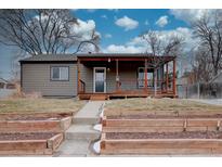 Charming home featuring a covered front porch with wooden accents and a well-maintained front yard at 3290 S Holly St, Denver, CO 80222