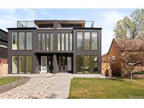 Modern home featuring a flat roof, dark metal siding, large windows, and minimalist landscaping at 4236 Zuni St, Denver, CO 80211